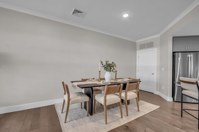 55 Pointe Pl # 106, Dover, NH 03820 - dining space with visible vents, crown molding, baseboards, and wood finished floors