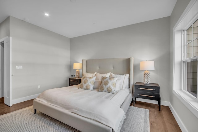 bedroom with multiple windows and wood-type flooring