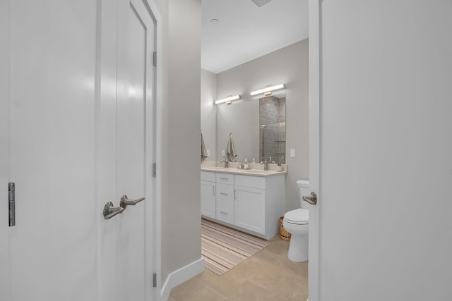 bathroom featuring tile patterned flooring, a shower with door, vanity, and toilet