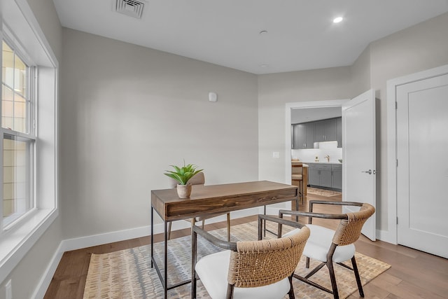 office space with light hardwood / wood-style flooring and sink