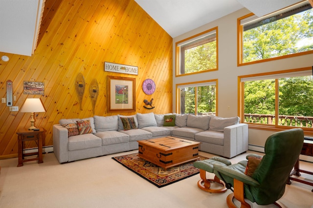 carpeted living room featuring a baseboard heating unit, high vaulted ceiling, and wood walls