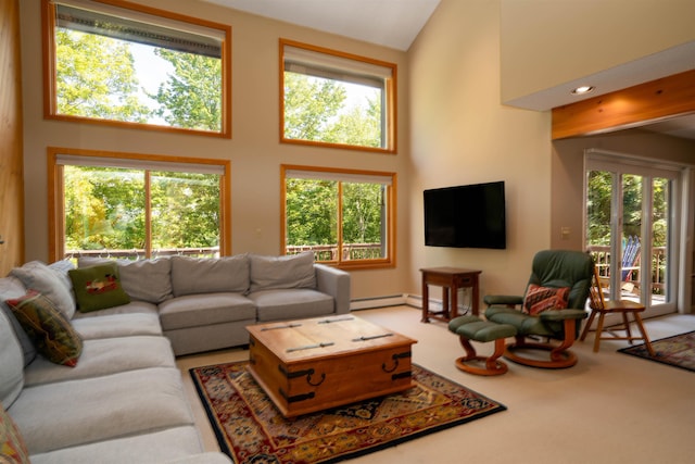 carpeted living room featuring a towering ceiling, a baseboard radiator, and a healthy amount of sunlight