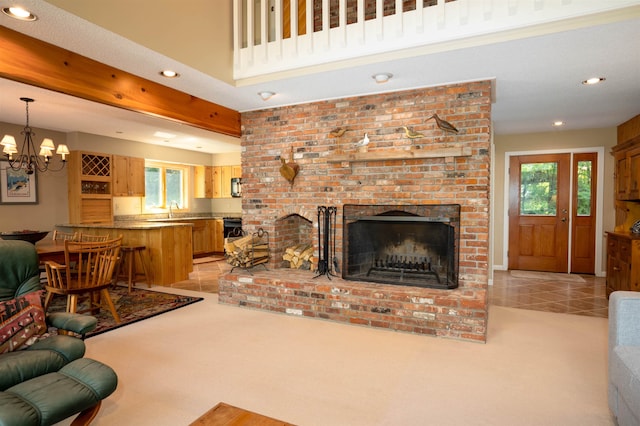 carpeted living room featuring a fireplace, a notable chandelier, and sink