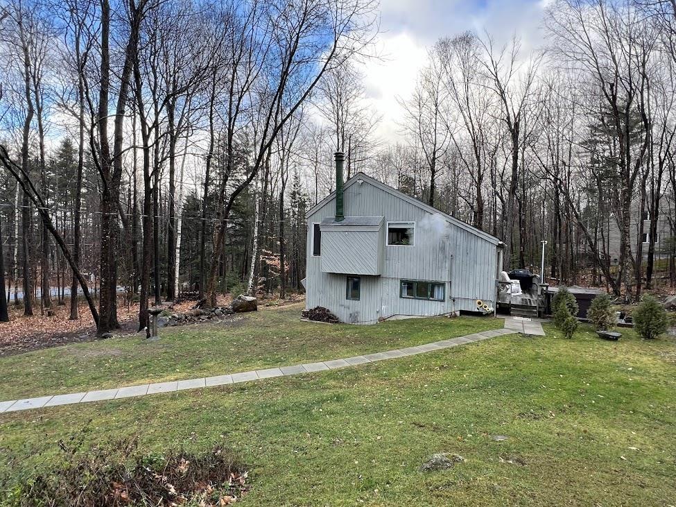 view of property exterior with a chimney and a yard