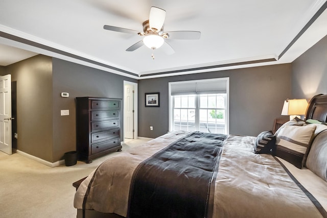 bedroom featuring light colored carpet, a raised ceiling, baseboards, and ceiling fan