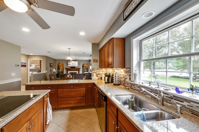 kitchen with backsplash, black electric stovetop, dishwasher, brown cabinetry, and a sink