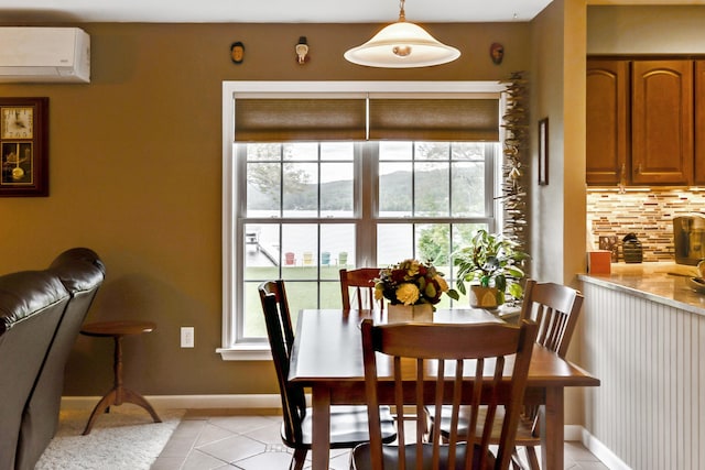 dining room with light tile patterned flooring, plenty of natural light, a wall mounted AC, and baseboards