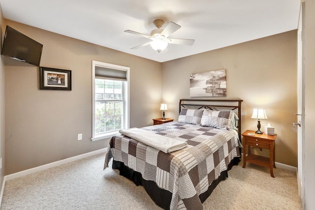 bedroom with baseboards, light colored carpet, and a ceiling fan