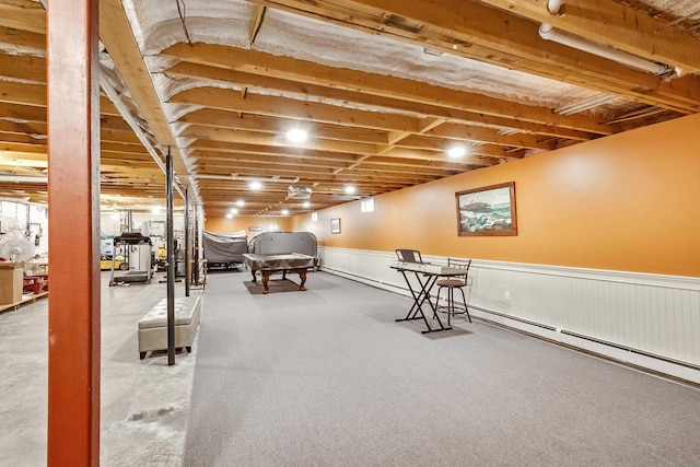 interior space with a wainscoted wall and a baseboard heating unit