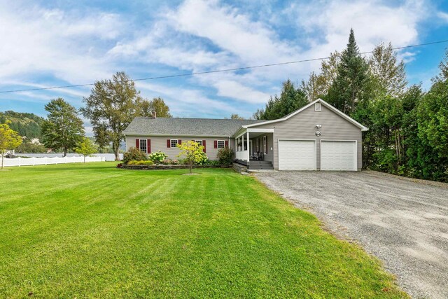 single story home with a garage and a front lawn