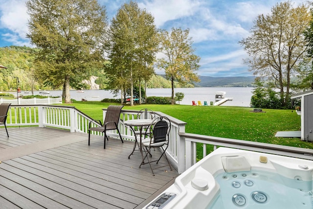 wooden deck with a yard, a water and mountain view, and an outdoor hot tub