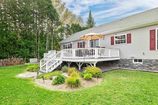 rear view of house featuring a yard and a wooden deck