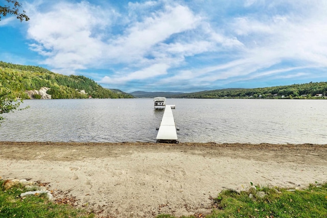 property view of water featuring a mountain view and a dock