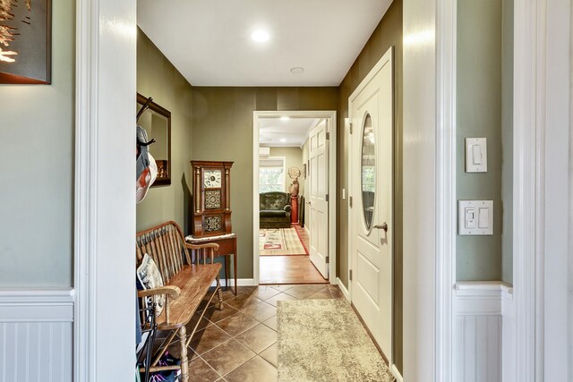 kitchen featuring stainless steel dishwasher, ceiling fan, kitchen peninsula, black electric stovetop, and light tile patterned flooring