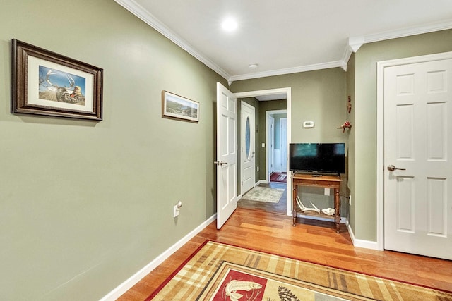 hallway featuring light wood-type flooring, baseboards, and ornamental molding