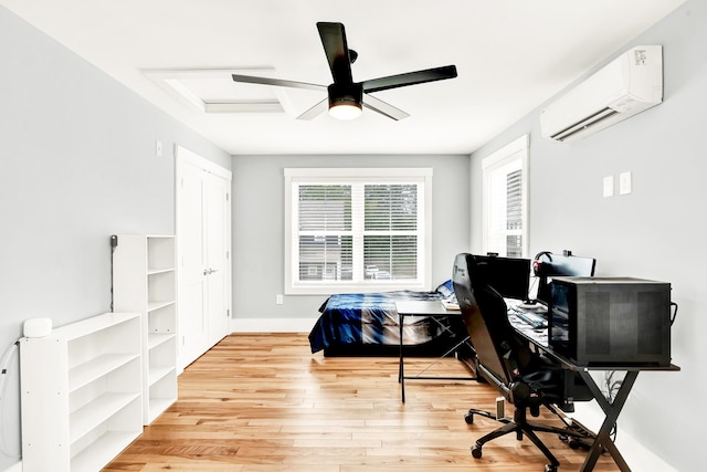 bedroom featuring light wood-type flooring, ceiling fan, and a wall mounted air conditioner