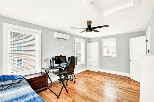 bedroom with a wall unit AC and light hardwood / wood-style flooring