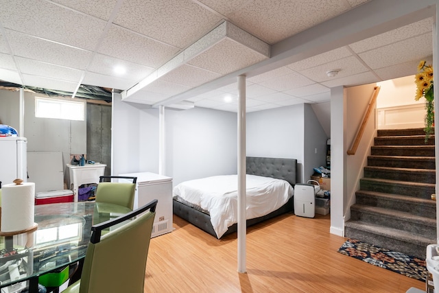 bedroom featuring light hardwood / wood-style flooring and a paneled ceiling