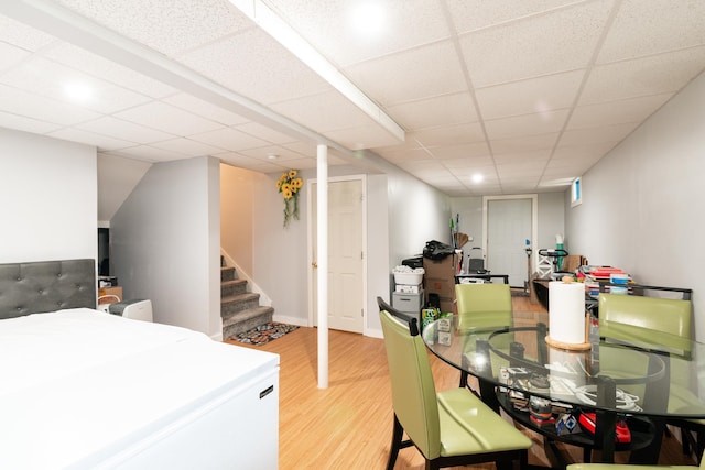 dining area featuring wood-type flooring and a drop ceiling