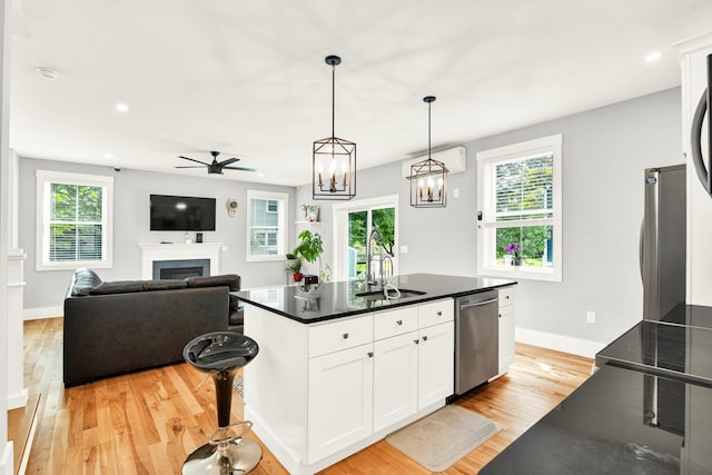 kitchen with a center island with sink, a wealth of natural light, appliances with stainless steel finishes, and white cabinetry