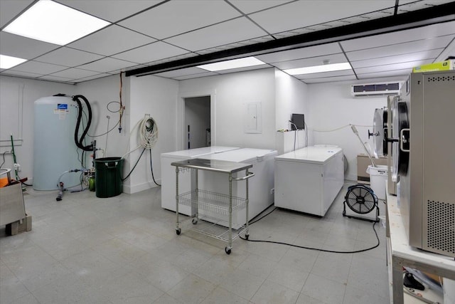 basement with a wall mounted AC, electric panel, fridge, a drop ceiling, and water heater