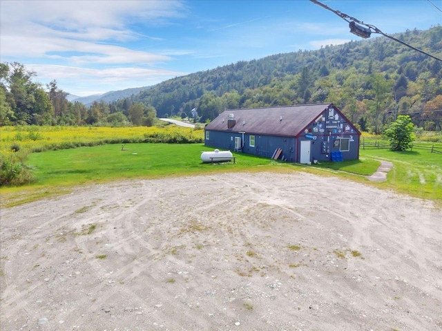 exterior space with a mountain view, a lawn, and a rural view