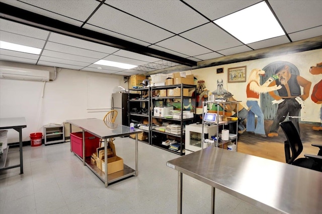 basement featuring stainless steel fridge, a paneled ceiling, and a wall mounted air conditioner