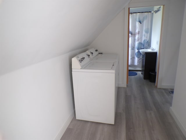 laundry room with washer and clothes dryer and hardwood / wood-style floors