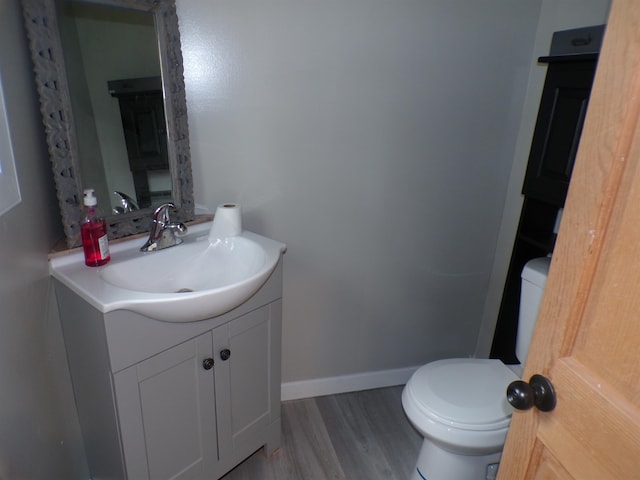 bathroom featuring vanity, toilet, and hardwood / wood-style floors