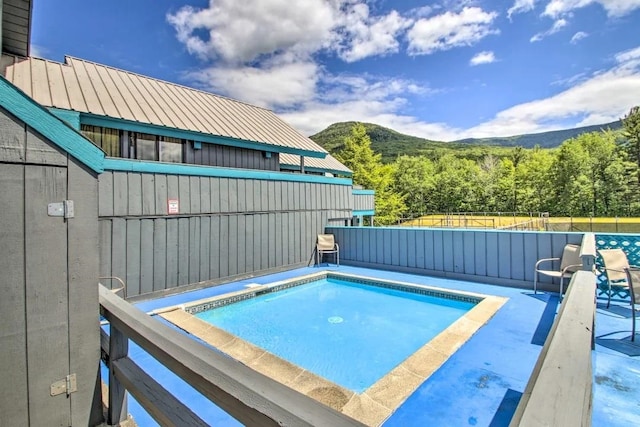 view of swimming pool featuring a mountain view and a jacuzzi