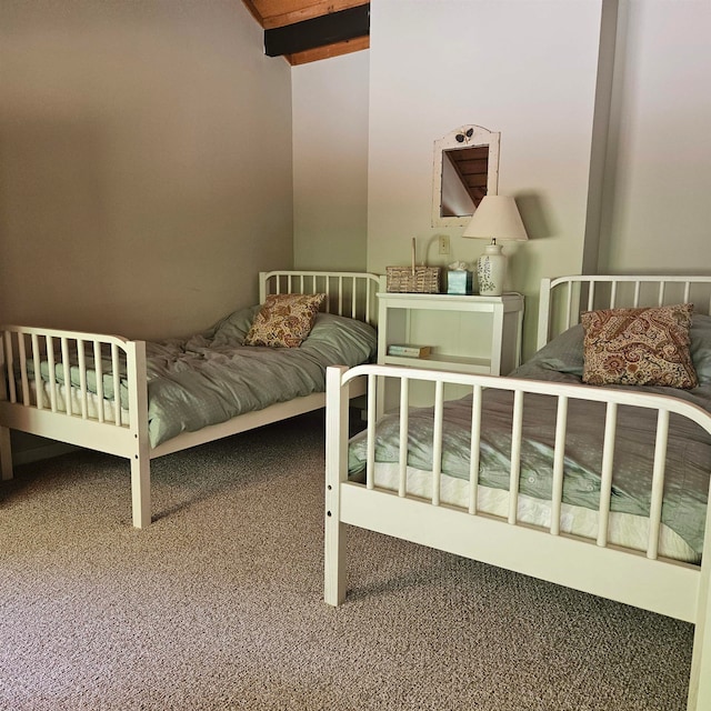 carpeted bedroom with beam ceiling