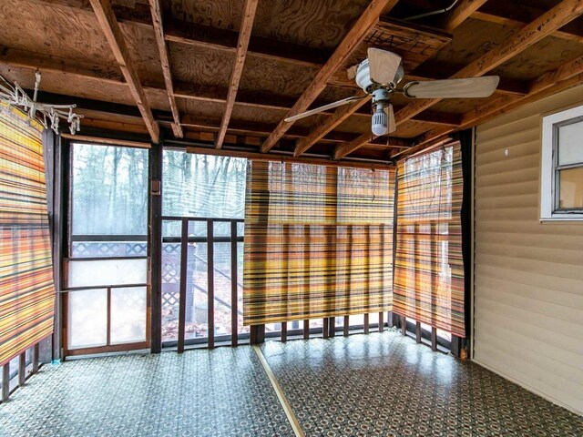 unfurnished sunroom featuring ceiling fan