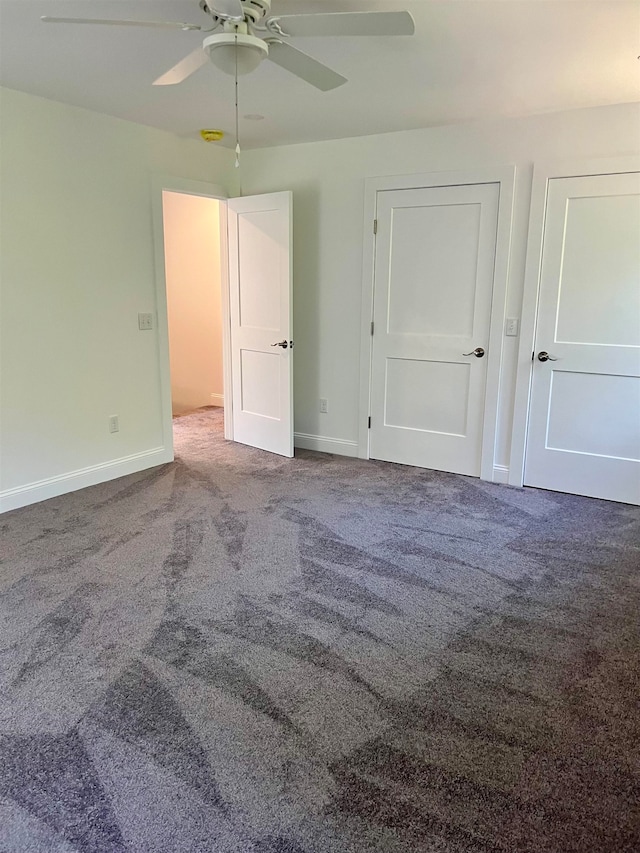 interior space with carpet floors and ceiling fan