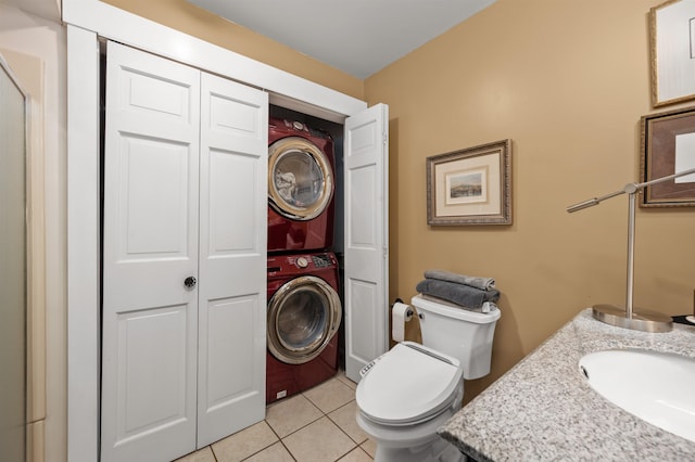 bathroom with tile patterned floors, vanity, toilet, and stacked washer / dryer