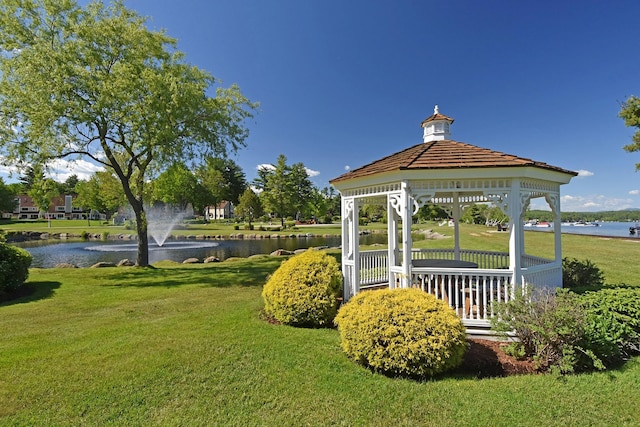 view of property's community with a water view, a lawn, and a gazebo