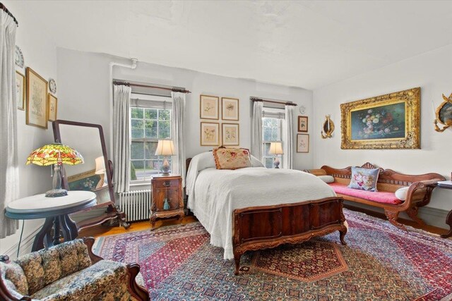 bedroom with radiator and hardwood / wood-style flooring