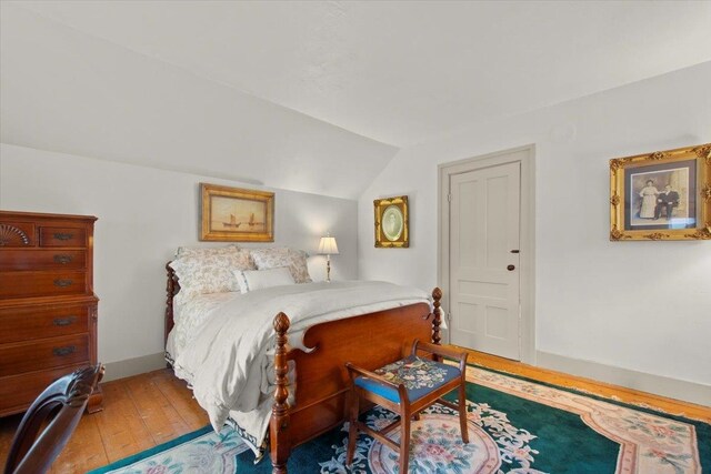 bedroom with lofted ceiling and light hardwood / wood-style floors