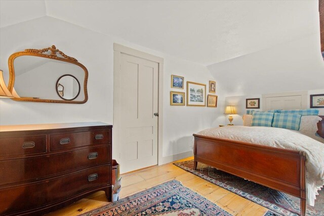 bedroom featuring vaulted ceiling and light hardwood / wood-style floors