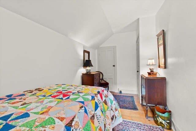 bedroom featuring lofted ceiling and light hardwood / wood-style flooring