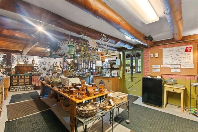 carpeted dining room featuring beam ceiling