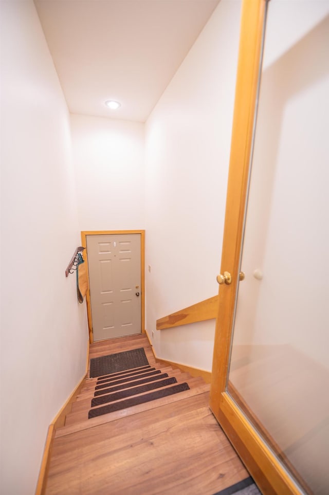 stairs featuring recessed lighting, baseboards, and wood finished floors