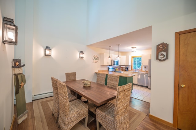 dining area featuring light wood-style floors and baseboard heating