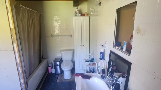 bathroom with toilet, shower / tub combo, and tile walls