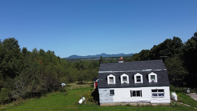 view of outbuilding featuring a mountain view and a lawn