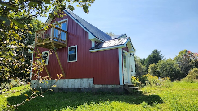 view of property exterior featuring a balcony and a yard