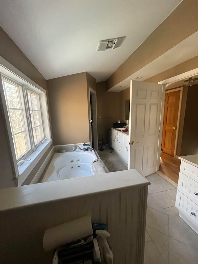 bathroom with tile patterned flooring and a washtub