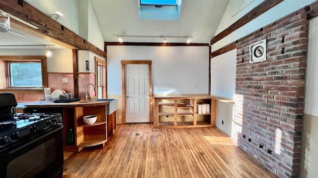 misc room with lofted ceiling, sink, and light hardwood / wood-style flooring