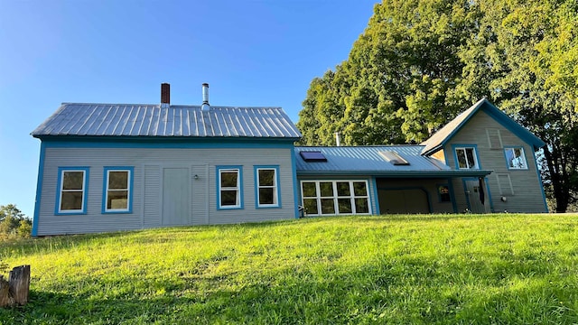 rear view of house featuring a yard