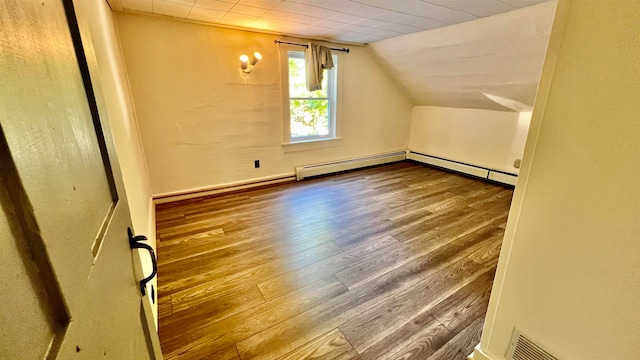 bonus room with a baseboard heating unit, vaulted ceiling, and wood-type flooring