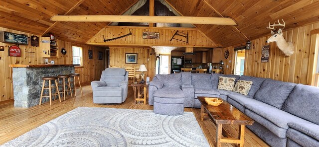 living room with wooden walls and vaulted ceiling with beams